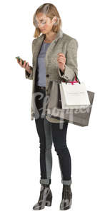 woman with shopping bags standing and texting