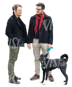 two men and a dog standing and talking