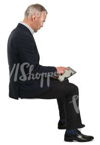 businessman sitting and checking his tablet