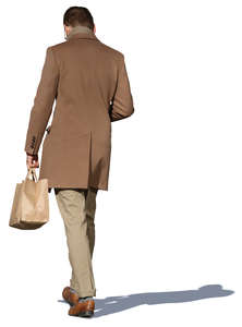 man in a light brown jacket walking