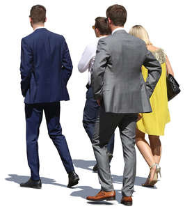 group of people in formal clothing walking in sunlight