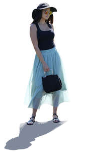 backlit woman in a light blue skirt standing