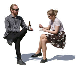 man and woman sitting in a street cafe