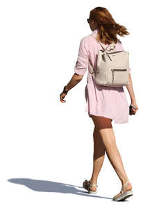 woman in a pink summer dress walking hastily