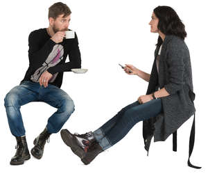 man and woman sitting in a cafe and drinking coffee