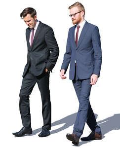 two men in suits walking and talking