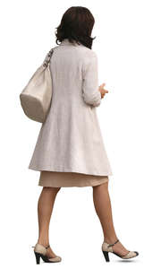 woman in a beige overcoat walking