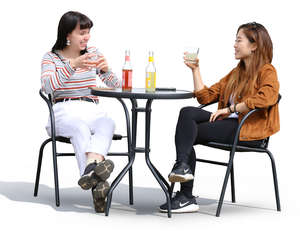 two women sitting and talking in a street cafe