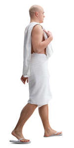 man in a towel and fliplops walking