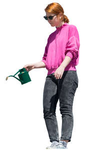 woman standing on a balcony and watering plants