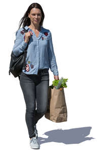 woman with a bag of groceries walking