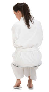 woman in a white bathrobe sitting