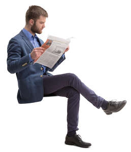 man in a suit sitting and reading a newspaper