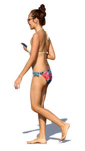 woman in a bikini walking and smiling