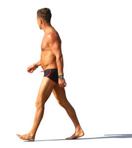 man in a swimsuit walking on the beach