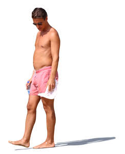 man in pink shorts standing on the beach