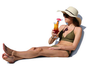 woman in a bikini sitting and drinking cocktail