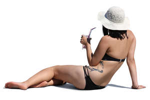 woman relaxing on the beach and drinking cocktail