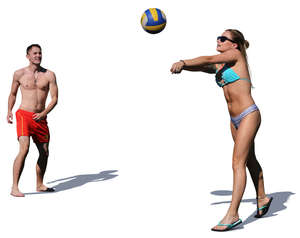 man and woman playing volleyball on the beach