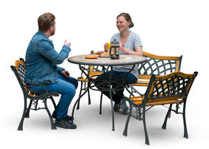 man and woman sitting at a terrace table and drinking coffee
