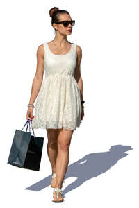 woman in a white summer dress with a shopping bag walking