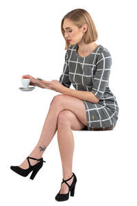 woman in a grey dress sitting in a cafe