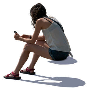 backlit woman sitting and texting