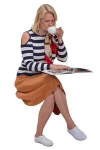 woman drinking coffee and reading a magazine