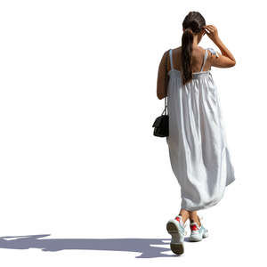 sidelit woman in a white summer dress walking