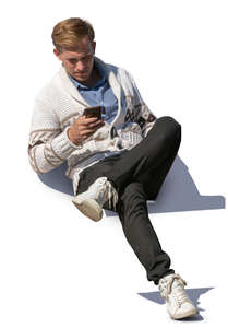 man sitting and checking his phone