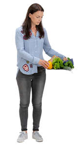 woman laying vegetables on a kitchen table