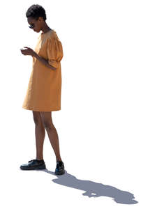 backlit african woman in a yellow dress standing