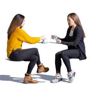 two teenage girls sitting in a cafe