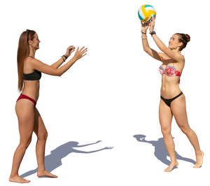 two women in bikinis playing beach volley