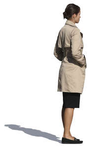 woman in a trenchcoat standing with her hands in her pockets