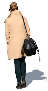 woman in a beige overcoat walking