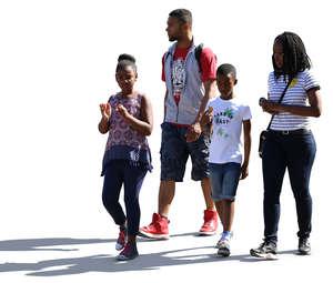 backlit african family of four walking down the street 