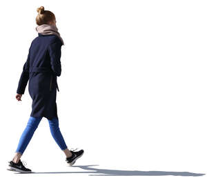 backlit young woman walking down the street