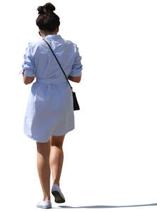 backlit woman on a dress walking on the street