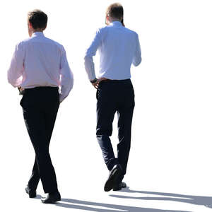 two backlit businessmen walking