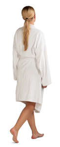 barefoot woman in a white bathrobe walking 