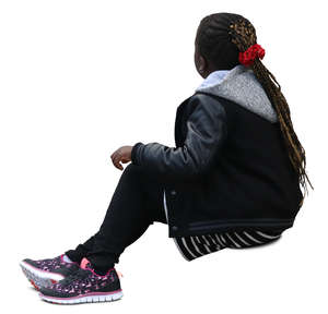 black girl with braided hair sitting on the sidewalk
