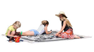 mother with two daughters sitting on a picnic blanket