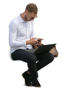 man with a laptop and phone sitting