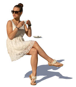 woman in a white summer dress sitting in a cafe