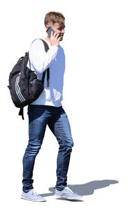 young man with a backpack walking and talking on the phone