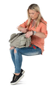 woman sitting and opening her handbag