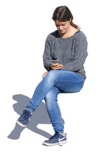 woman sitting and looking at her phone