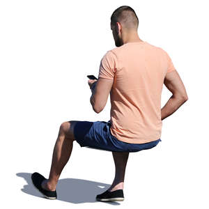 man with a phone sitting seen from behind