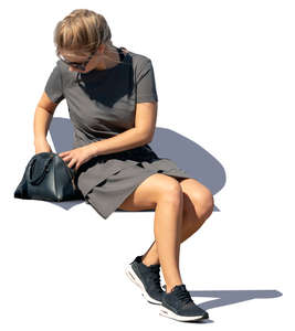 woman sitting and taking smth from her purse